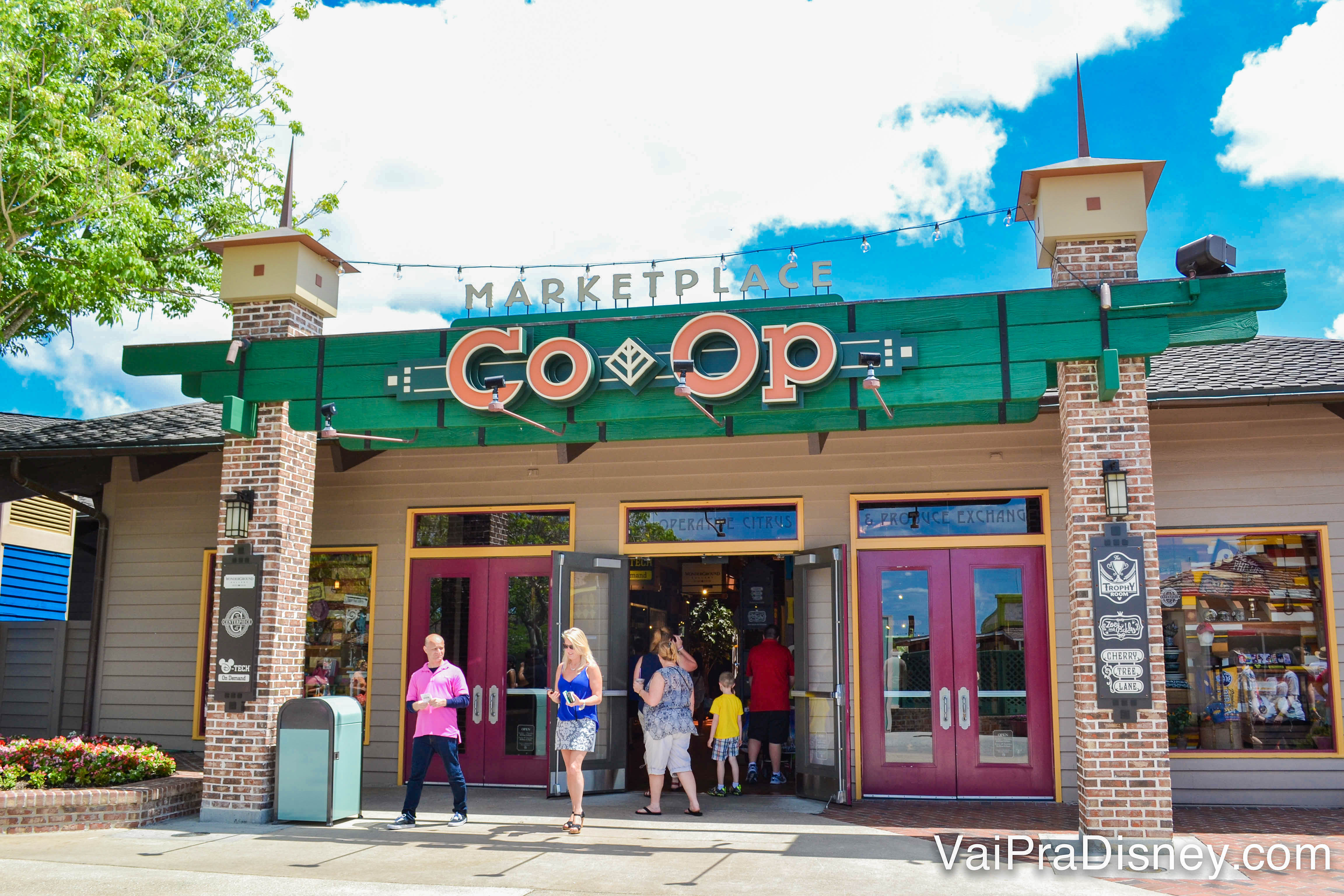 Foto da entrada do Marketplace Co-op de Disney Springs. A fachada é verde e as letras estão em laranja. 