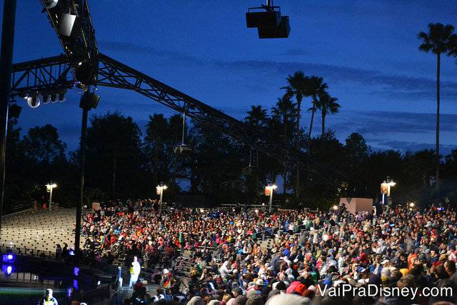 Foto da plateia do show de fogos Fantasmic, no Hollywood Studios, sentada nas arquibancadas. 