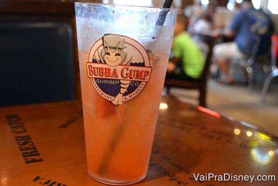 Aqui a Strawberry Lemonade vem com pedaços de morango mesmo. Deliciosa. Foto de um copo com limonada de morango e o logo do restaurante. 