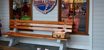 Foto da entrada do restaurante Bubba Gump, que fica no CityWalk da Universal, mostrando os famosos itens do filme Forrest Gump - os tênis, o banco de madeira e a mala.