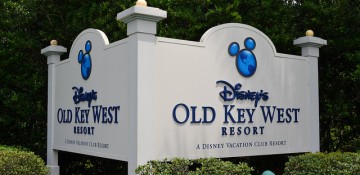 Foto da placa do Disney's Old Key West Resort na Disney, com fundo branco e texto em azul escuro, com um Mickey também azul em cima do nome do hotel