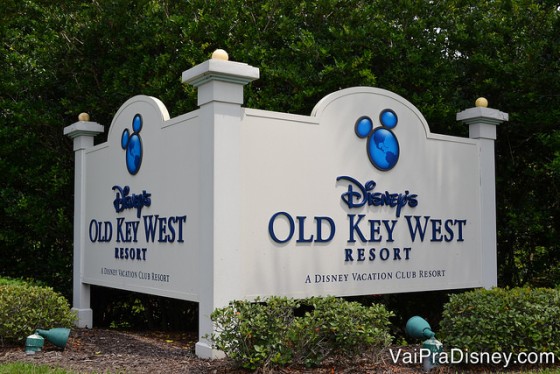 Foto da placa do Disney's Old Key West Resort na Disney, com fundo branco e texto em azul escuro, com um Mickey também azul em cima do nome do hotel 