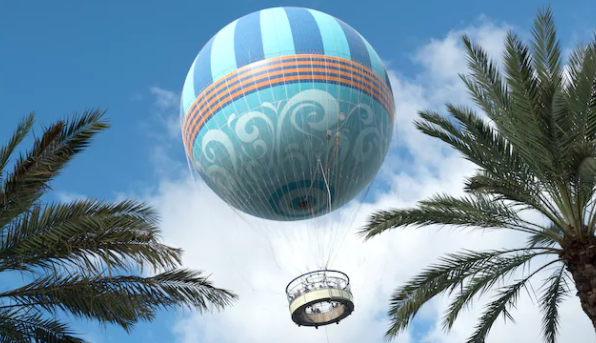 Foto do balão do Disney Springs no ar, durante um passeio, com o céu azul ao fundo 