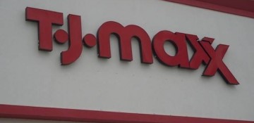 Foto da placa da loja T.J. Maxx em Orlando. O fundo é branco e o nome da loja está escrito em vermelho.