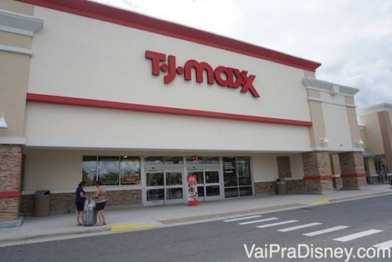 Uma das unidades da T.J.Maxx na região de Orlando. Foto da fachada da loja T.J. Maxx em Orlando. O fundo é branco e o nome da loja está escrito em vermelho. 