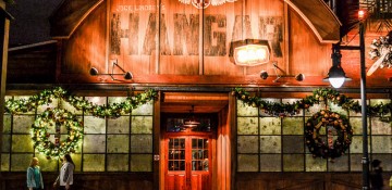 Foto da fachada do Jock Lindsey's Hangar Bar em Disney Springs, com iluminação alaranjada e estilo industrial.