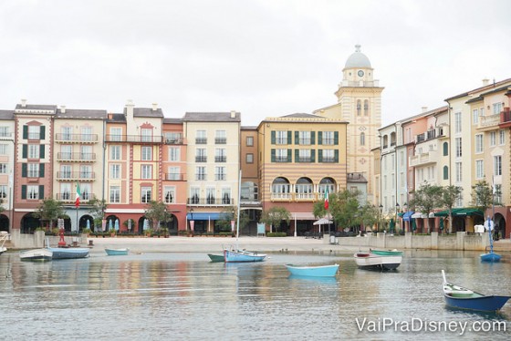 Foto do Portofino Bay durante o dia, com o lago, barcos passando e as lojas e restaurantes mais ao fundo 