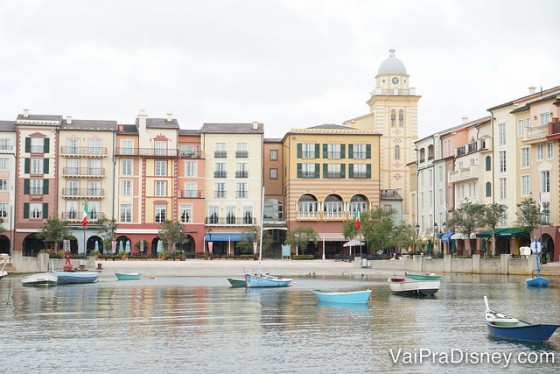 Foto do Portofino Bay durante o dia, com o lago, barcos passando e as lojas e restaurantes mais ao fundo 