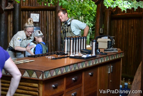 Os guias ajudando uma criança a colocar as roupas e equipamentos para o Wild Africa Trek.