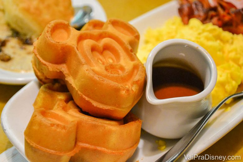 Waffles do Mickey ao lado de uma leiteira com calda de chocolate 