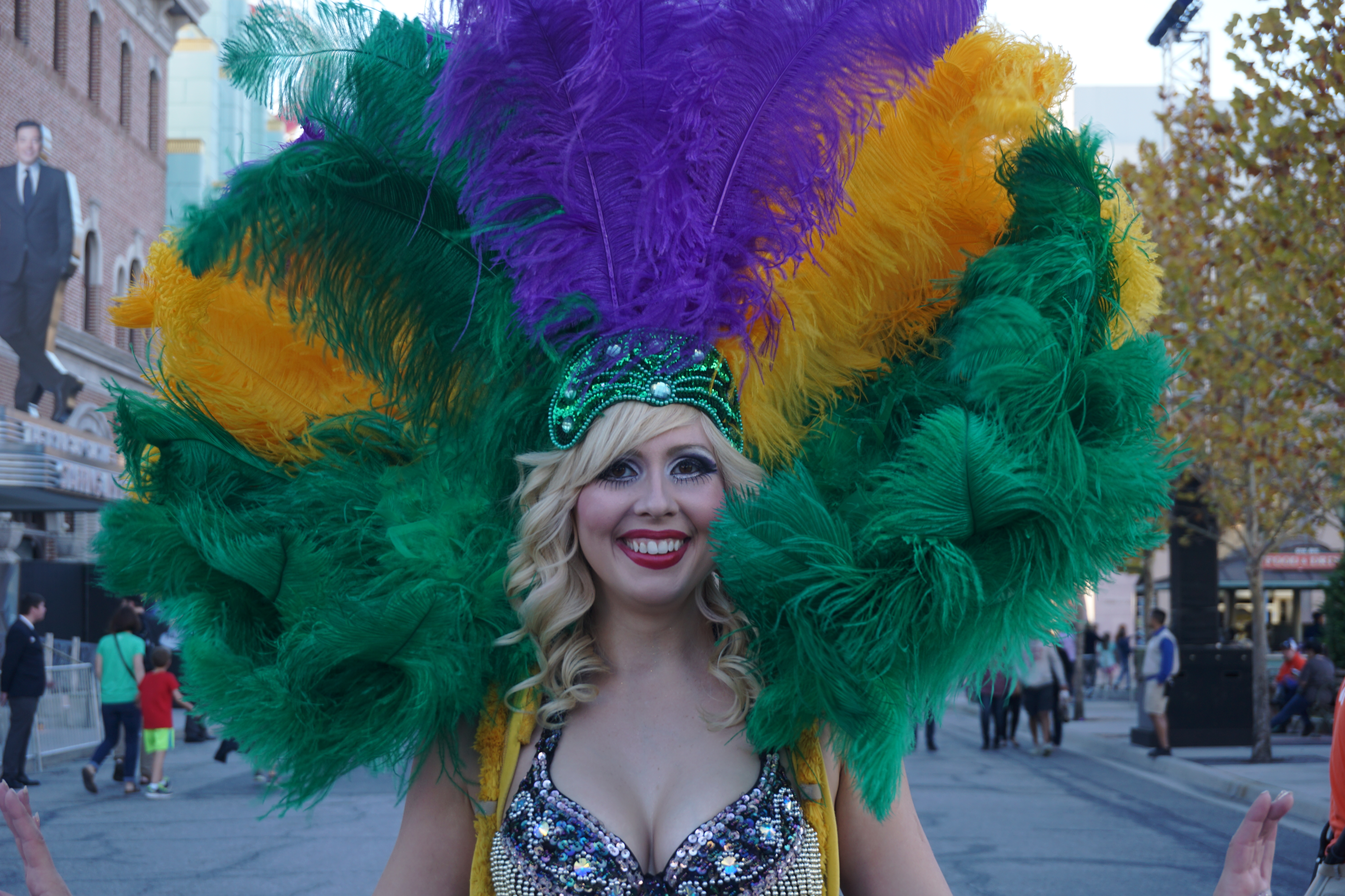 Foto de uma dançarina caracterizada para o Mardi Gras, com plumas coloridas na cabeça. 