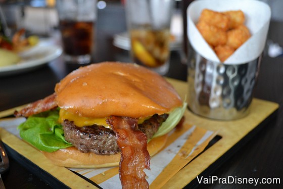 Foto do cheeseburguer no prato, acompanhado de batatas 