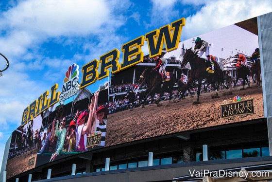 Foto do exterior do bar e restaurante NBC Sports Grill & Brew, no CityWalk da Universal, com sua tela gigante embaixo do letreiro.