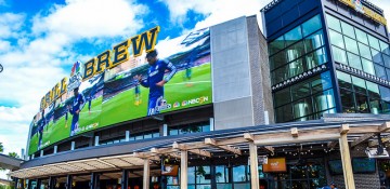 Foto do exterior do bar e restaurante NBC Sports Grill & Brew, no CityWalk da Universal, com sua tela gigante embaixo do letreiro.