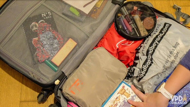 Foto do interior de uma mala de viagem, com diversos saquinhos para guardar roupas e uma nécessaire 