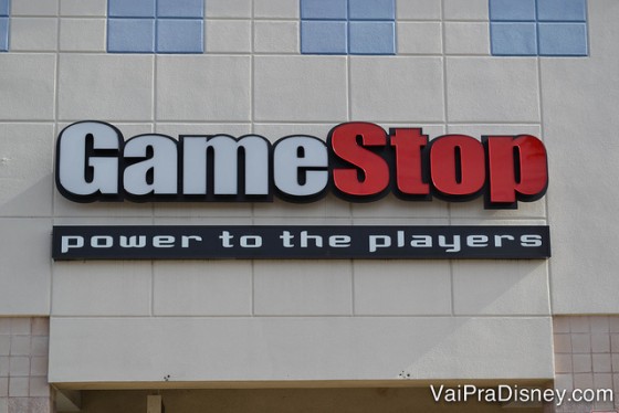 Game Stop em Orlando. Uma das minhas lojas preferidas na cidade. Foto da entrada da Game Stop em Orlando. A placa tem a palavra "Game" escrita em branco e "Stop" escrita em vermelho. 