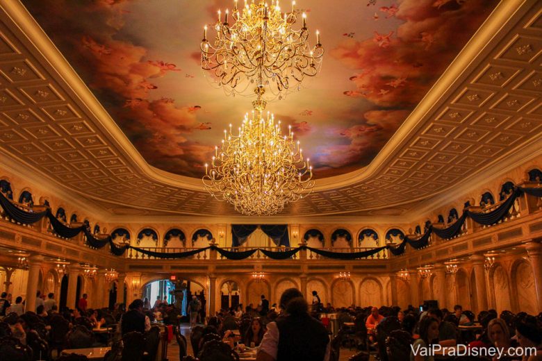 Foto da decoração, do lustre e das mesas no Be our Guest, o restaurante que fica no castelo da Fera no Magic Kingdom 