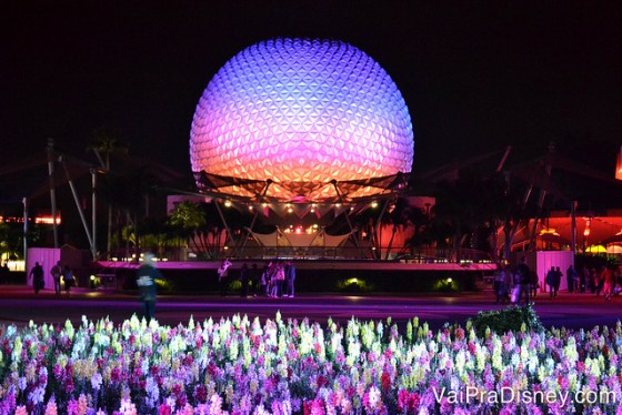 Foto da Spaceship Earth iluminada em rosa e lilás à noite 