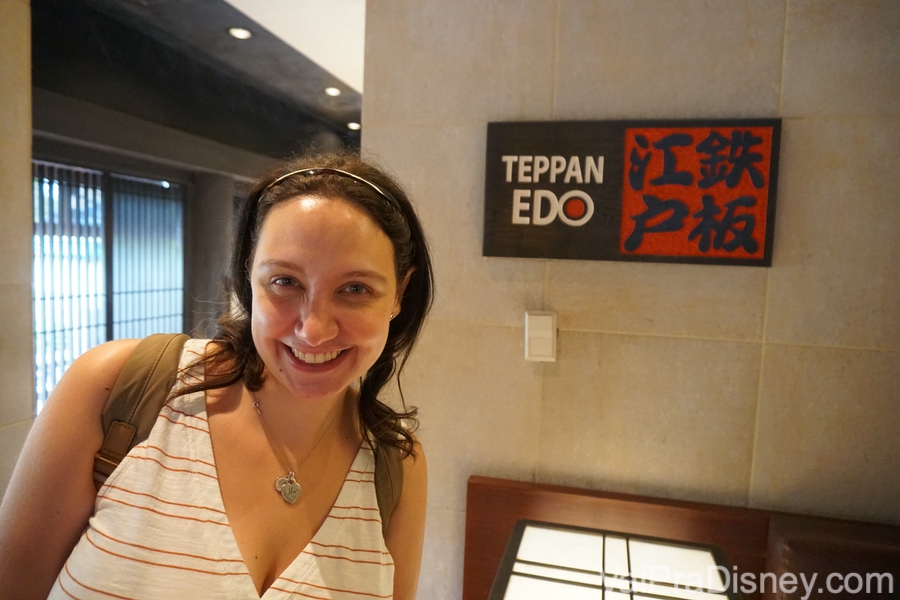 Foto da Renata em frente à placa com ideogramas japoneses do Teppan Edo, restaurante delicioso no Epcot.