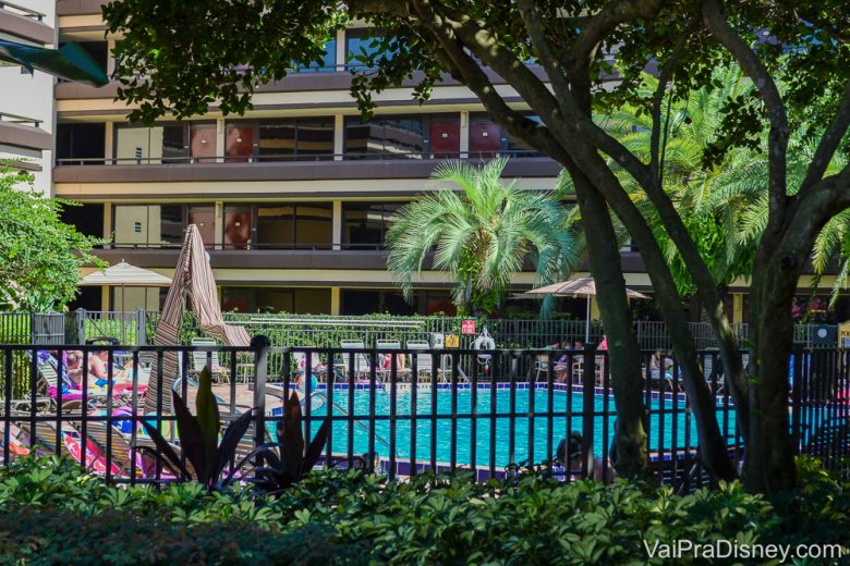 Foto da piscina de um dos hotéis de Orlando, com árvores e cadeiras de praia ao redor. 