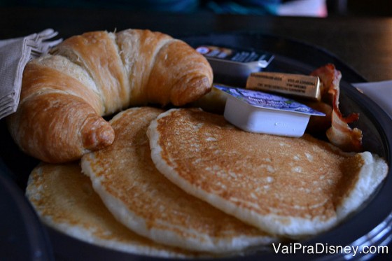 Prato com panquecas e croissant no café da manhã.