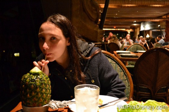 Foto da Renata bebendo o drinque clássico do Ohana, o Lapu Lapu, dentro de um abacaxi 