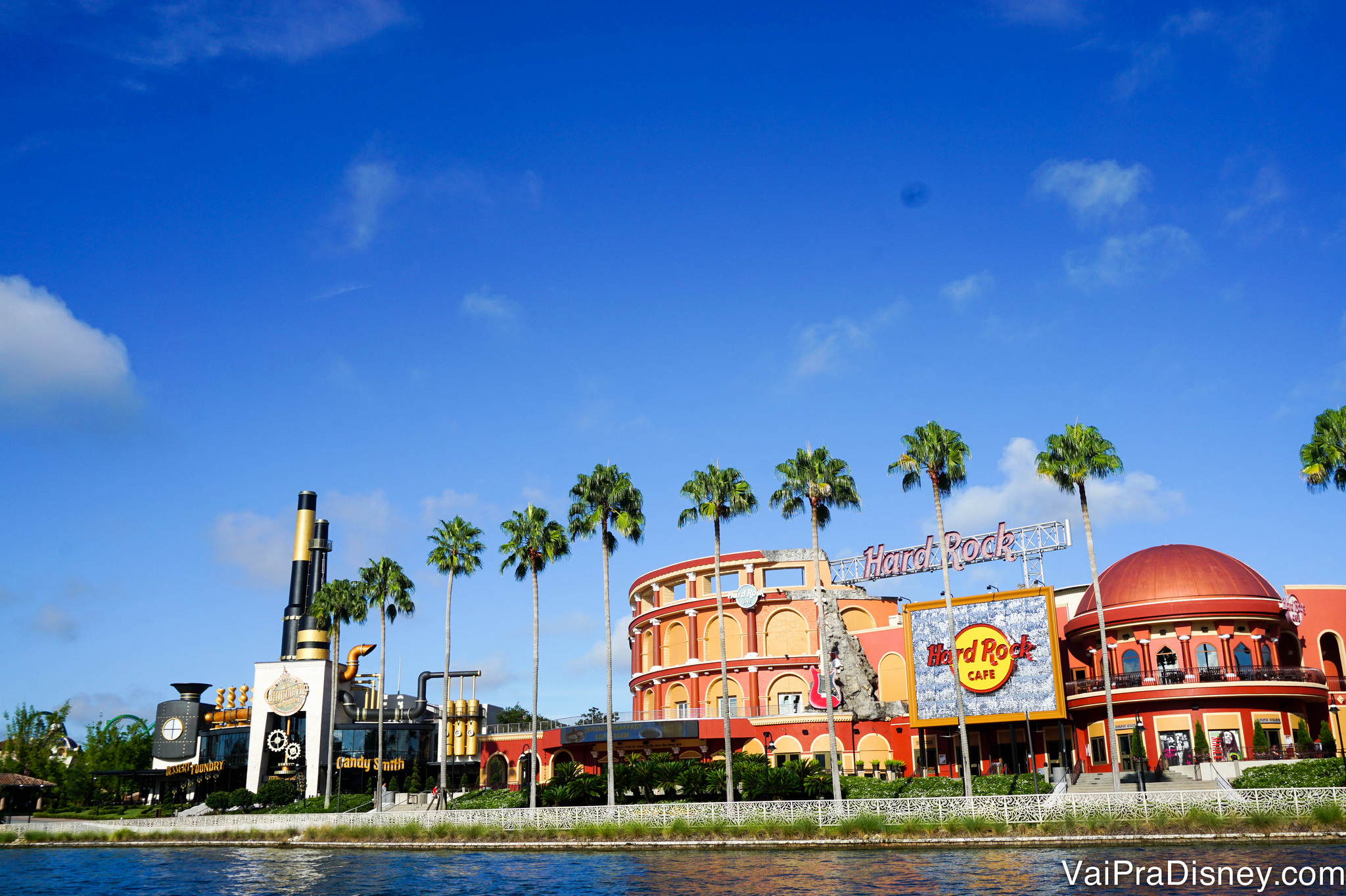 Foto do Citywalk com o lago em frente e o céu azul ao fundo. 