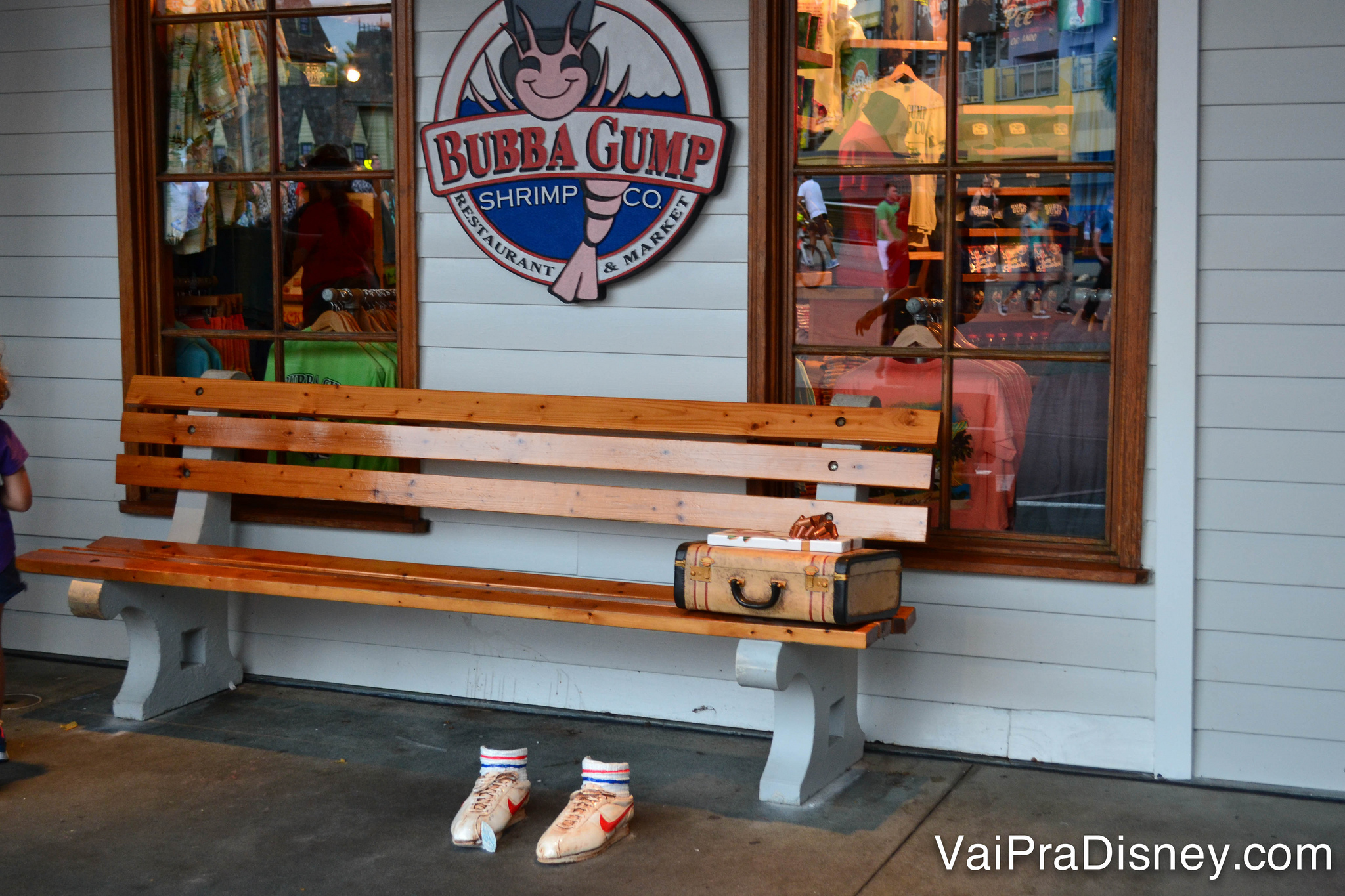 Foto do banco no exterior do Bubba Gump, com os tênis e a maleta de Forrest do filme Forrest Gump 