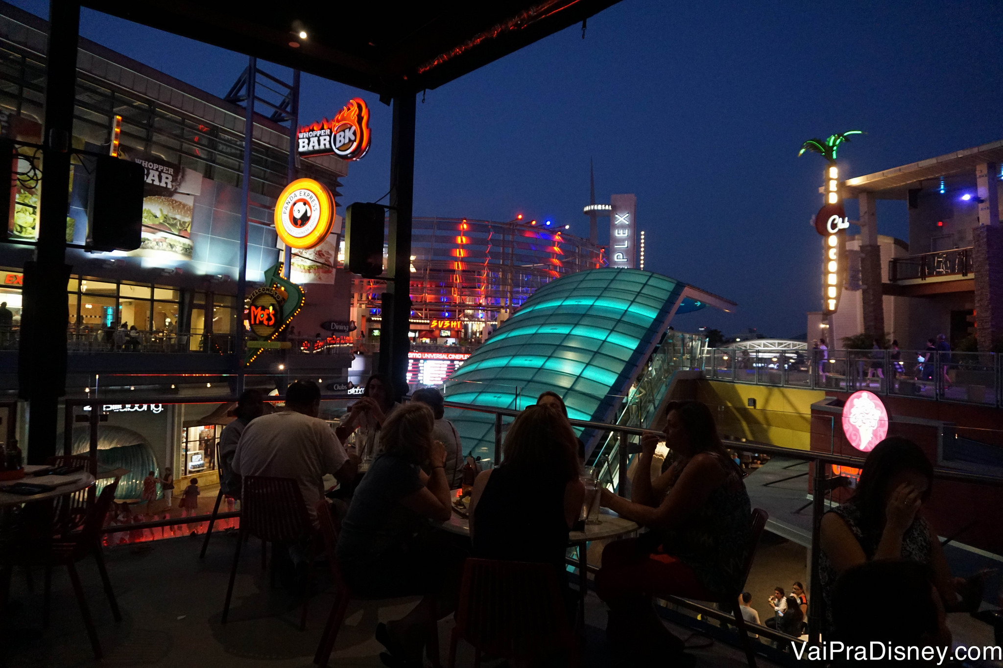 Foto da sacada de um restaurante à noite, com vista para o CityWalk iluminado 