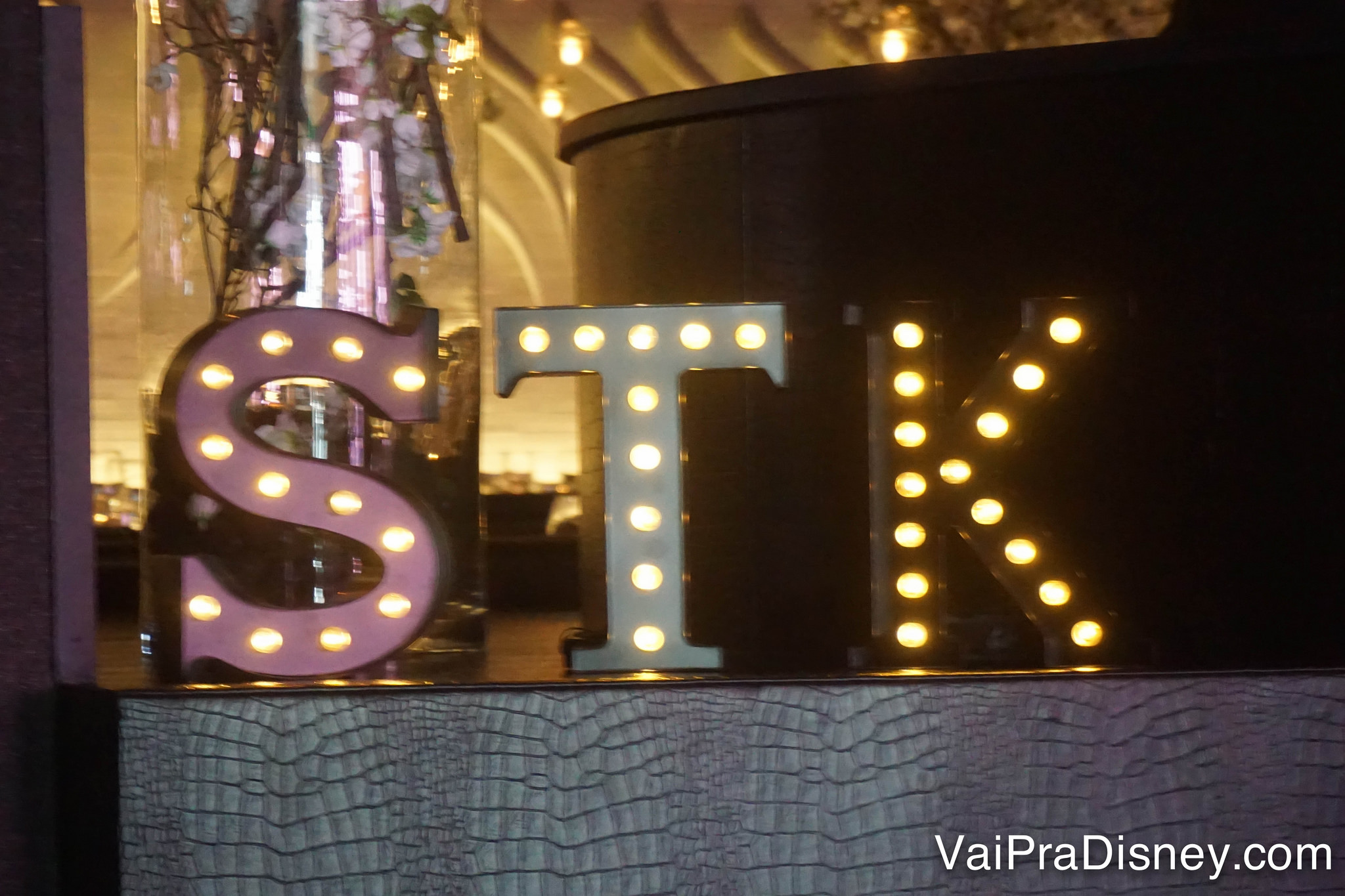 Um letreiro iluminado com o nome do restaurante, STK 