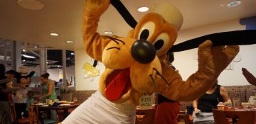 Foto do Pluto com avental de chef, posando para a câmera no Chef Mickey's