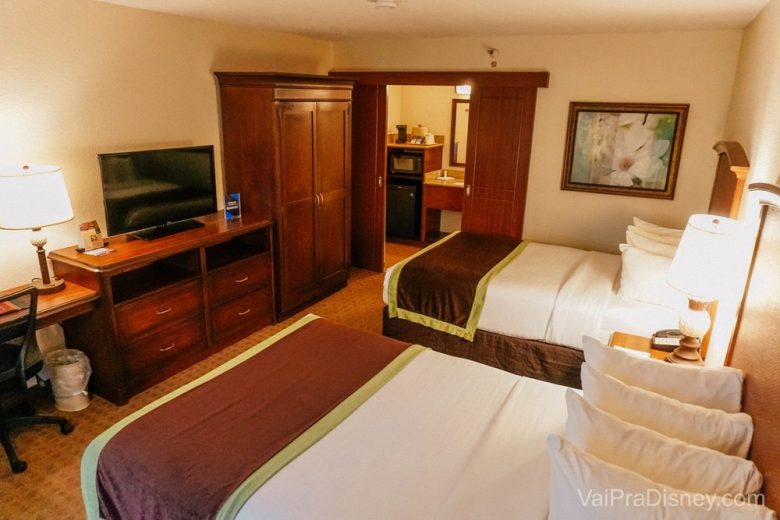 Quarto padrão do Rosen Inn Lake Buena Vista, com duas camas de casal, uma televisão, um armário e uma escrivaninha.