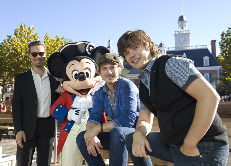 Foto dos irmãos do trio Hanson com o Mickey no Epcot 