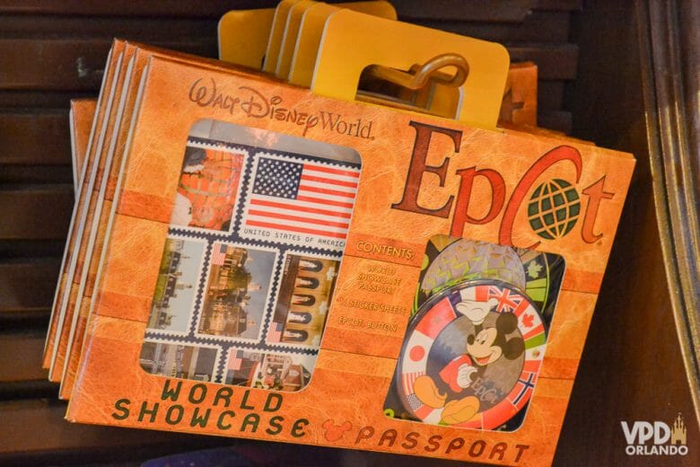 O passaporte do Epcot é uma lembrança super legal! Foto do passaporte do Epcot, com várias bandeiras de países na capa e um pin do Mickey na embalagem 