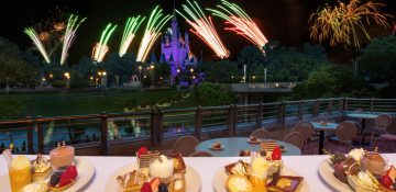 Foto do castelo da Cinderela com os fogos no céu ao redor durante a Fireworks Dessert Party, com docinhos na mesa em primeiro plano