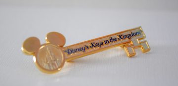 Foto da lembrancinha do Keys to the Kingdom, uma chave dourada com orelhas de Mickey e o nome do tour em azul