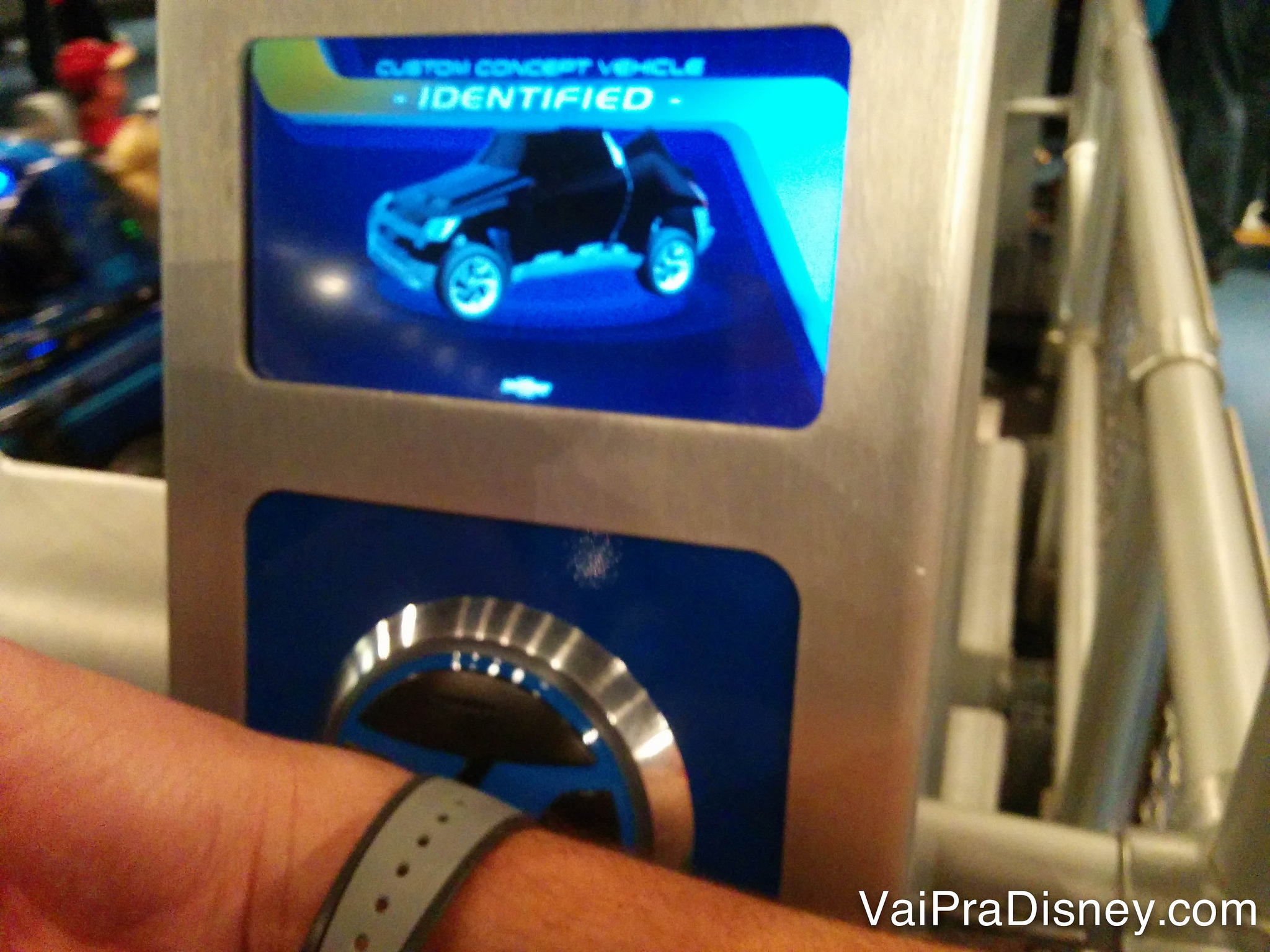 Brincadeira dentro da atração Test Track no Epcot, que já usa a MagicBand para identificar cada participante. Foto de um visitante encostando sua MagicBand no leitor do Test Track, do Epcot