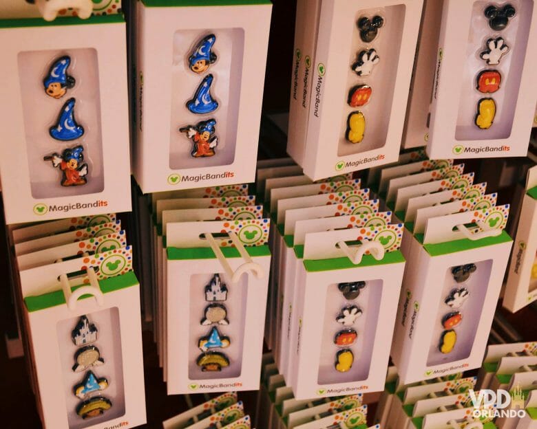 Acessórios para quem quiser enfeitar a sua MagicBand. Foto dos acessórios para colocar na MagicBand que são as carinhas de personagens como Mickey, Minnie e Donald, à venda em uma loja 