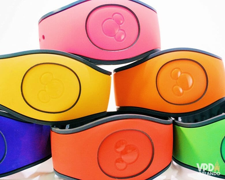 Foto de uma pilha de MagicBands da Disney nas cores rosa, amarela, laranja, vermelha e verde