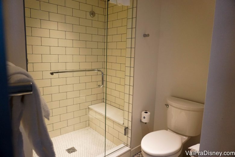 Foto do banheiro mostrando o box (sem banheira) transparente e o vaso sanitário ao lado 