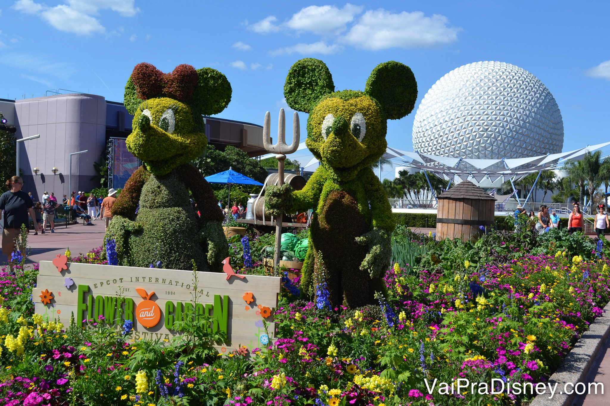 Foto das topiárias do Mickey e da Minnie durante o Flower & Garden, com a Spaceship Earth ao fundo 