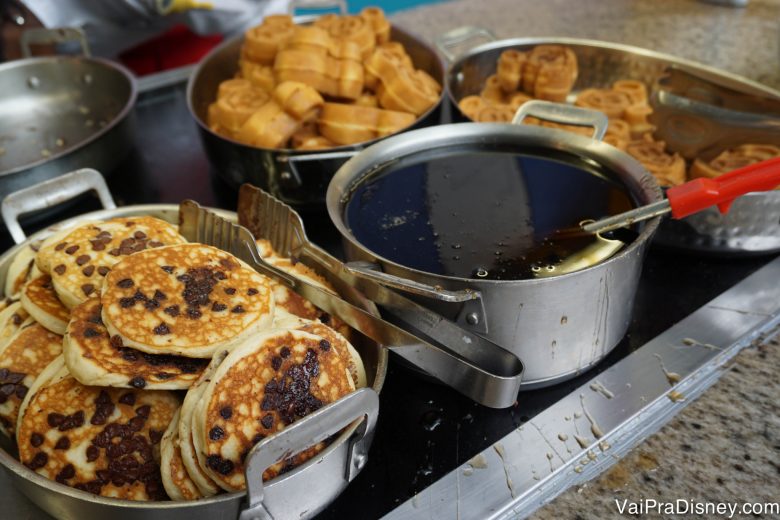 Foto de panquecas com gotas de chocolate, xarope de maple e waffles do Mickey no buffet