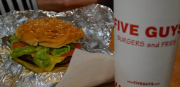 Foto do hambúrguer do Five Guys em Orlando, com um copo de refrigerante ao lado