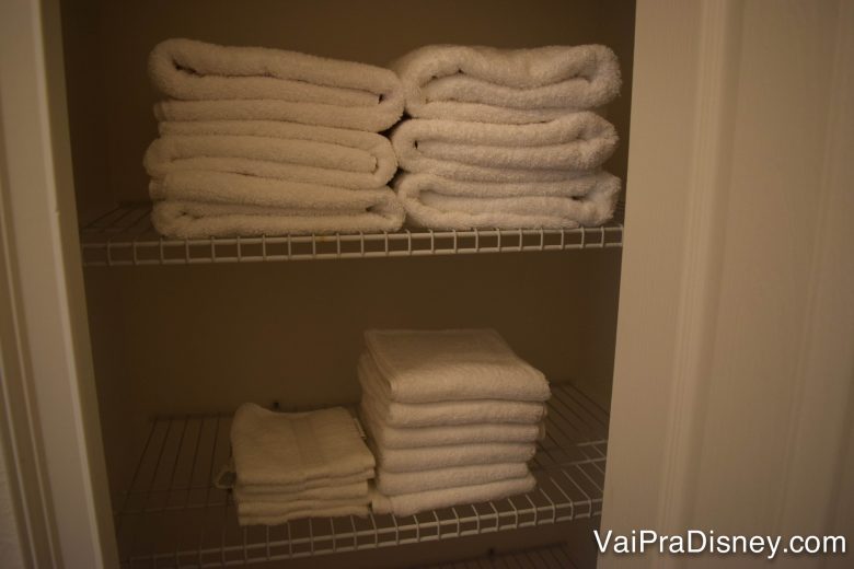 Tem gente que acha que precisa levar toalha, lençol e etc. Em geral, não precisa, a maioria das casas tem!! Foto do armário de toalhas na casa alugada, com diversas toalhas brancas empilhadas 
