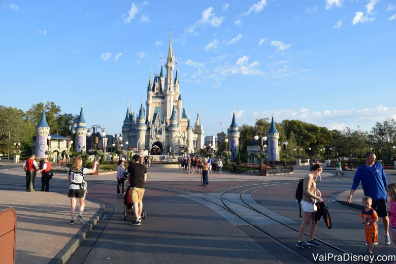 Foto do Magic Kingdom logo cedo, com poucos visitantes passeando e o Castelo da Cinderela visível ao fundo. 