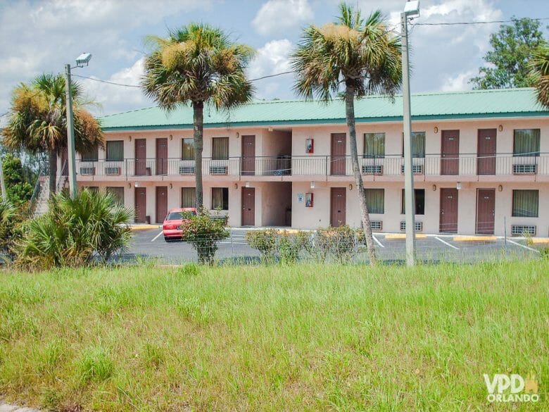 Evite hotéis sem controle de acesso aos quartos, como o da foto acima. Qualquer um pode bater na porta do seu quarto, e a segurança é menor. Foto de um hotel que tem acesso pela rua, com um carro estacionado à frente e palmeiras em volta. 