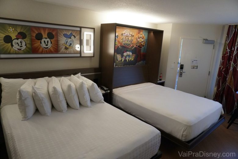 Depois da reforma, todos os quartos devem seguir esse mesmo padrão! Foto do quarto reformado do All Star Movies, com duas camas queen e alguns quadros do Mickey e outros personagens nas paredes