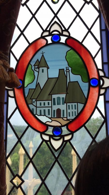 Como é a suíte do castelo da Cinderela no Magic Kingdom. Foto do vitral da suíte mostrando a casa da Cinderela 
