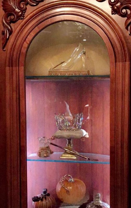 Olha o sapatinho aí! Foto do móvel que expõe o sapatinho de cristal, a coroa e a varinha da Fada Madrinha e uma abóbora. 