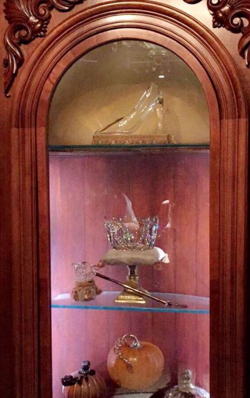 Olha o sapatinho aí! Foto do móvel que expõe o sapatinho de cristal, a coroa e a varinha da Fada Madrinha e uma abóbora. 